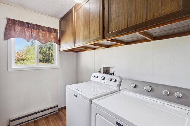 clothes washing area with cabinets, a textured ceiling, baseboard heating, dark wood-type flooring, and washing machine and clothes dryer