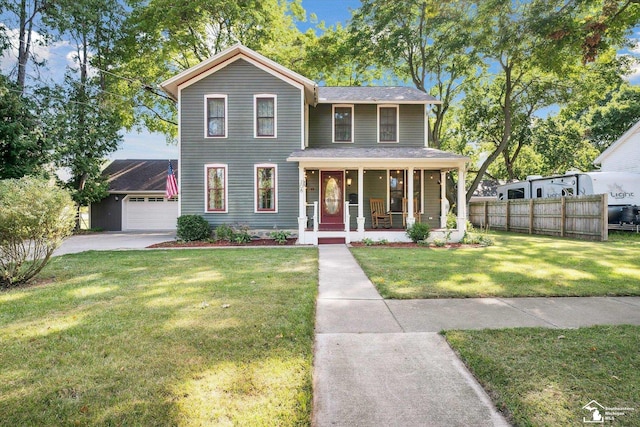 view of front facade featuring a front yard, a garage, covered porch, and an outbuilding