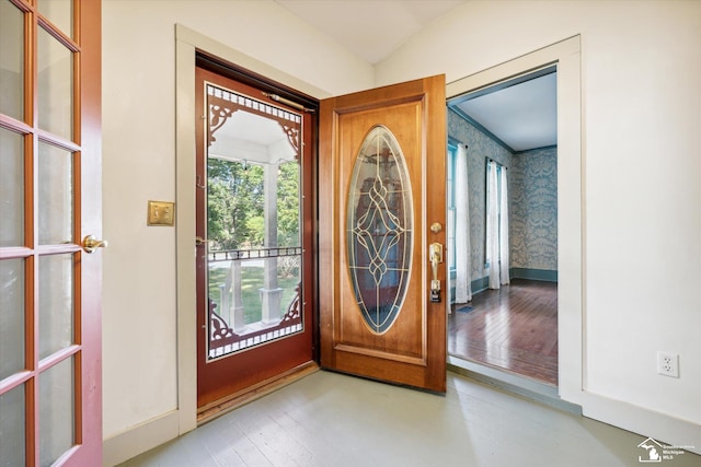 doorway to outside featuring lofted ceiling and a healthy amount of sunlight