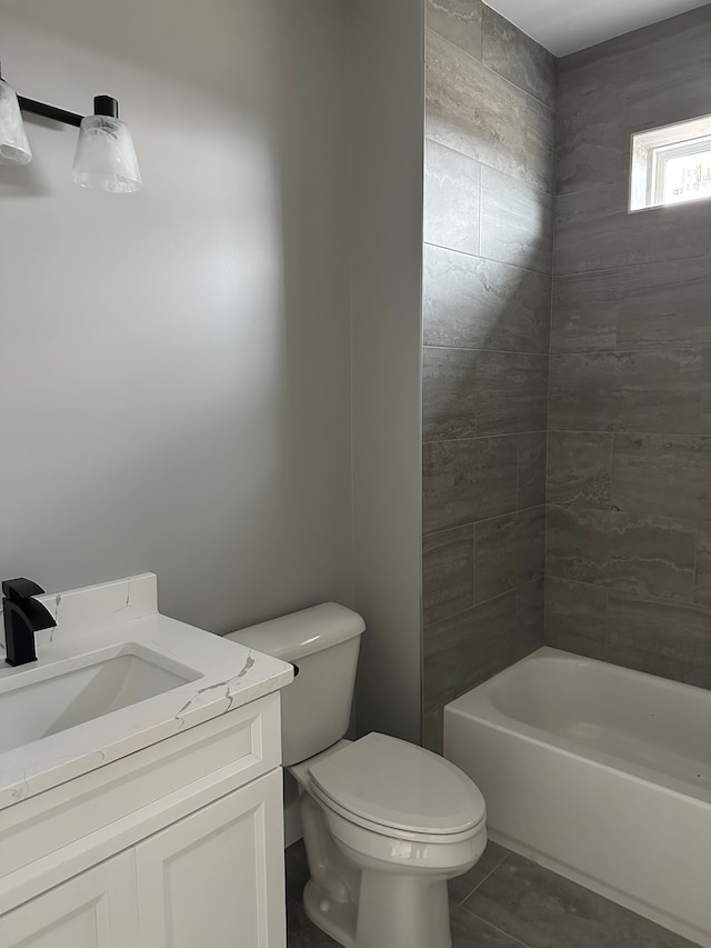 full bathroom with tiled shower / bath, vanity, toilet, and tile patterned floors