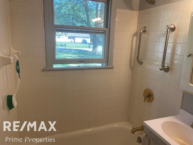 bathroom with vanity and tiled shower / bath