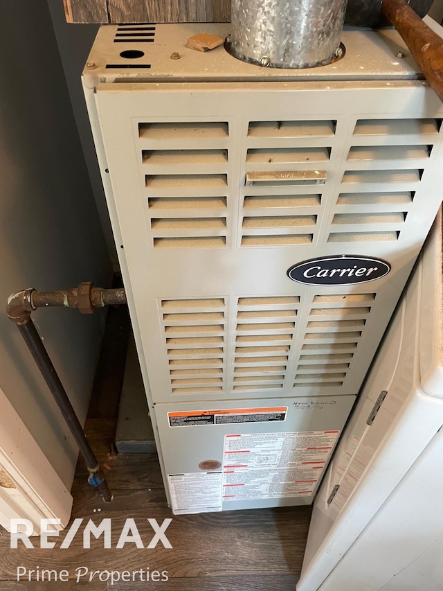 interior details with heating unit and hardwood / wood-style floors