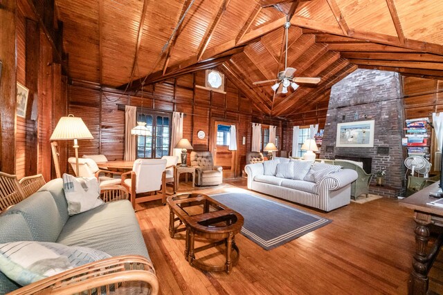 5212 Pier Rd, Coloma, MI 49038 - living area with wood walls, wood finished floors, wooden ceiling with exposed beams, a ceiling fan, and high vaulted ceiling