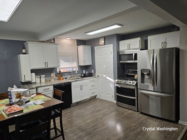 kitchen featuring white cabinetry, dark hardwood / wood-style flooring, stainless steel appliances, and light stone counters