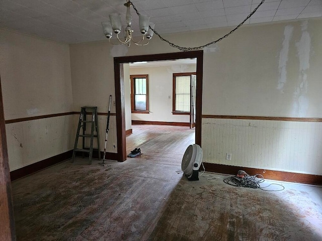 unfurnished room featuring hardwood / wood-style flooring and a notable chandelier