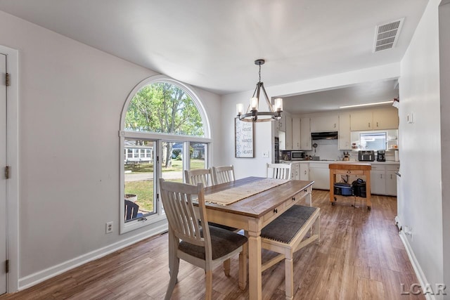 dining area with a notable chandelier and light wood-type flooring