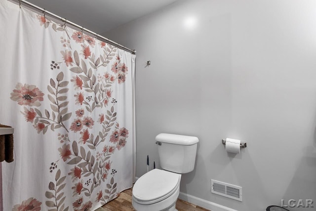 bathroom featuring toilet and wood-type flooring