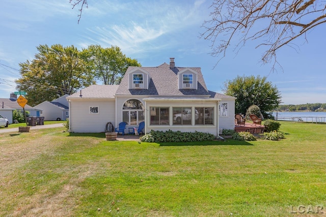 cape cod home featuring a sunroom, a wooden deck, and a front lawn