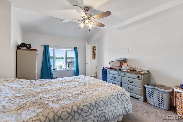 bedroom featuring light colored carpet, vaulted ceiling, ceiling fan, and a water view