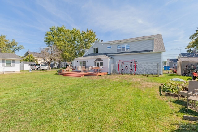 rear view of house featuring a wooden deck and a yard