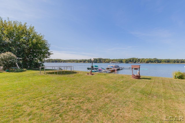 view of dock featuring a lawn and a water view