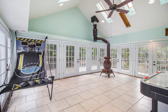 sunroom / solarium featuring lofted ceiling with skylight, french doors, and ceiling fan