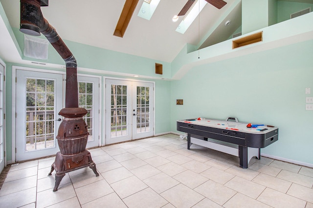 playroom featuring a skylight, ceiling fan, french doors, high vaulted ceiling, and light tile patterned flooring