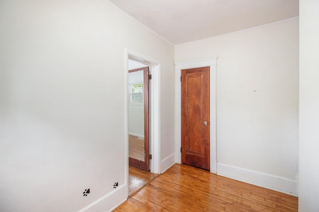 unfurnished room featuring crown molding and light wood-type flooring