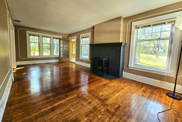 unfurnished living room featuring a brick fireplace and hardwood / wood-style flooring