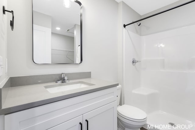 bathroom with vanity, toilet, and a shower