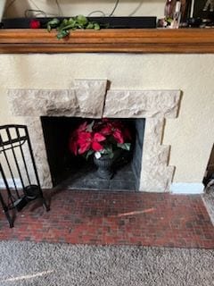 room details with carpet floors and a stone fireplace