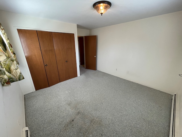 unfurnished bedroom featuring a closet and a baseboard heating unit