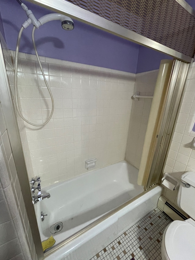 bathroom featuring tile patterned flooring, tiled shower / bath, and toilet