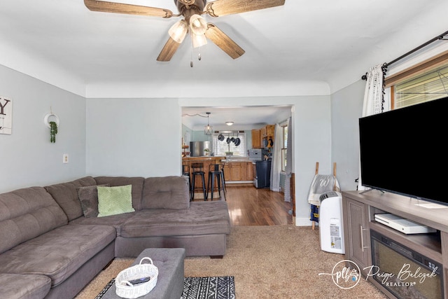 living room with dark hardwood / wood-style flooring, ceiling fan, and a healthy amount of sunlight