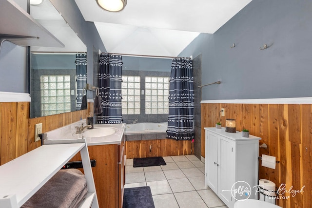 bathroom featuring tile patterned floors, vanity, vaulted ceiling, wooden walls, and a tub