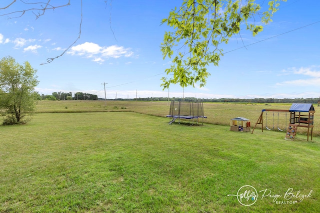 view of yard with a rural view, a trampoline, and a playground