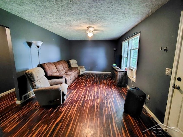 living room featuring ceiling fan, dark hardwood / wood-style flooring, and a textured ceiling