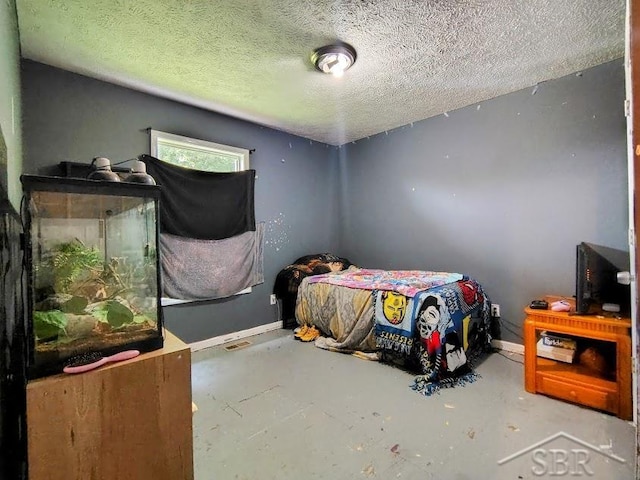 bedroom with a textured ceiling and concrete floors