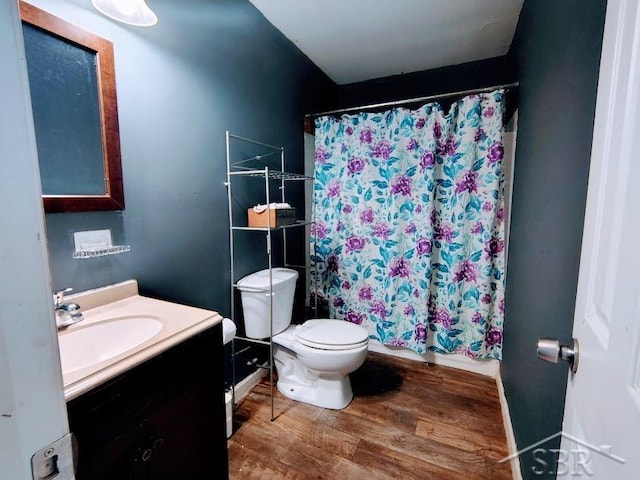 bathroom featuring walk in shower, hardwood / wood-style floors, vanity, and toilet