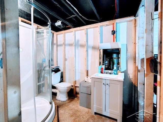 bathroom featuring vanity, toilet, and a shower with door