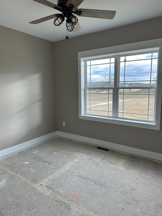 empty room with ceiling fan and a healthy amount of sunlight