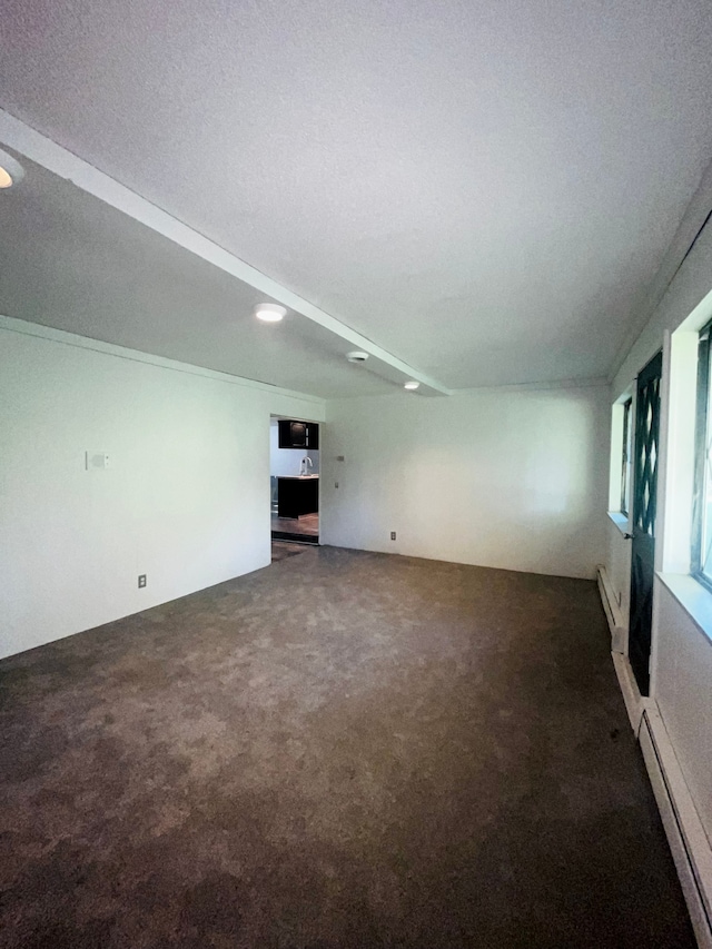 carpeted empty room with a textured ceiling and a baseboard heating unit