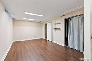 unfurnished room featuring ornamental molding and dark wood-type flooring