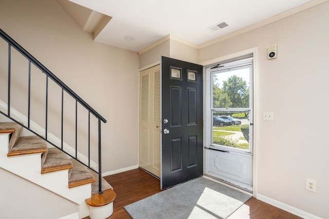 entrance foyer with crown molding and dark hardwood / wood-style flooring