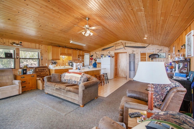 carpeted living room featuring wood ceiling, ceiling fan, lofted ceiling, and wooden walls