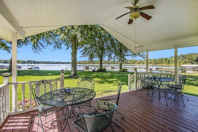 deck with a yard, a water view, and ceiling fan