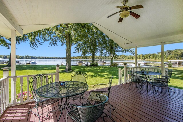 3055 E Baseline Rd, Gobles, MI 49055 - wooden deck with outdoor dining space, a water view, a ceiling fan, and a yard