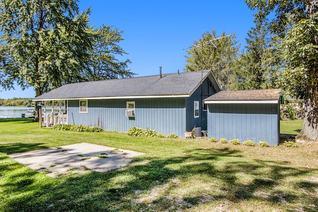 back of property with a yard and a water view