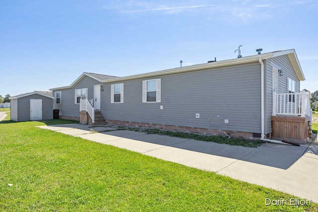 view of front of home with a shed and a front lawn