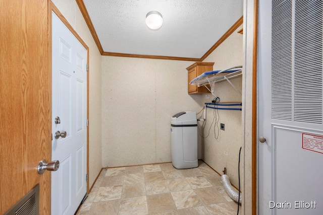 washroom with ornamental molding, cabinets, and a textured ceiling