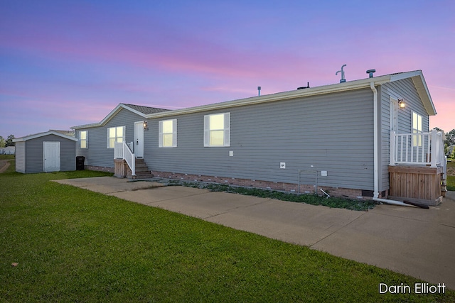 view of front facade featuring a yard and a storage shed