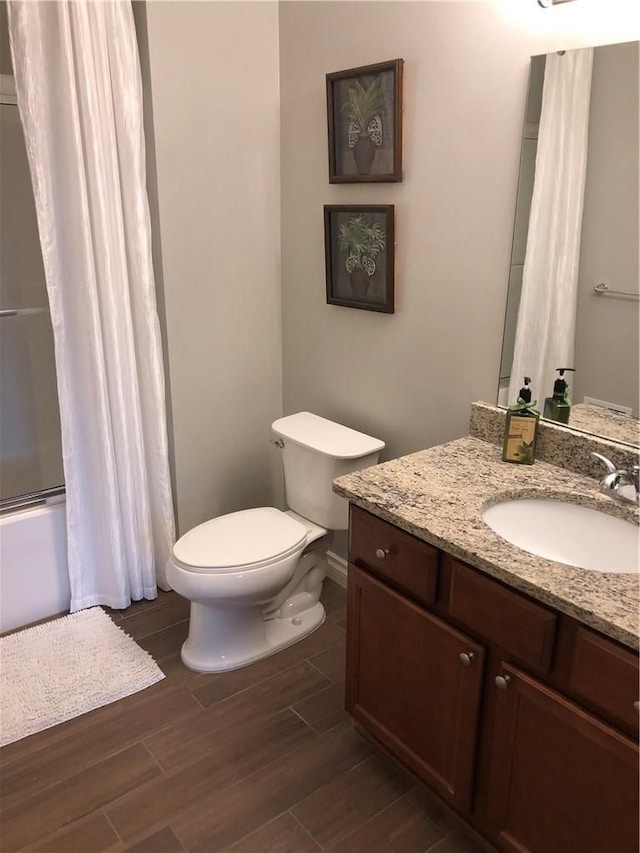 full bathroom featuring shower / bath combination, vanity, wood-type flooring, and toilet