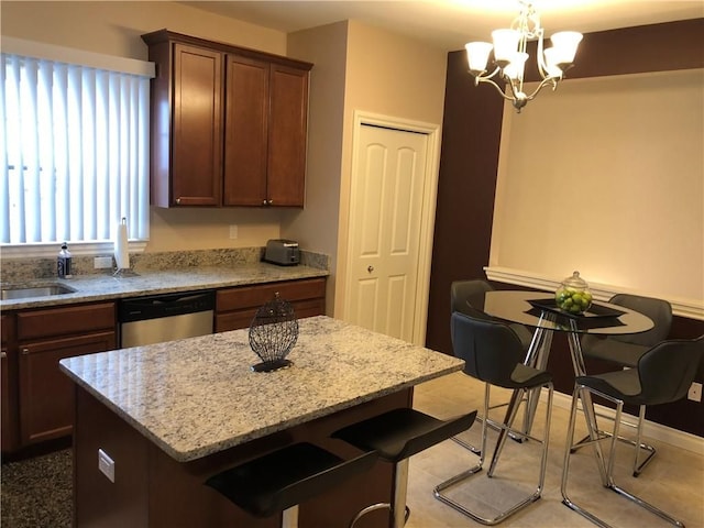 kitchen featuring dishwasher, a center island, a notable chandelier, decorative light fixtures, and a breakfast bar area