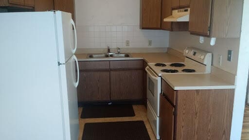 kitchen featuring white appliances, sink, and tasteful backsplash