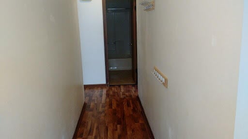 corridor with dark hardwood / wood-style flooring