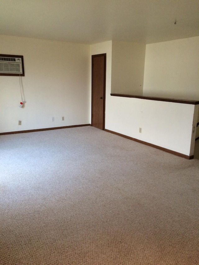 carpeted spare room featuring an AC wall unit