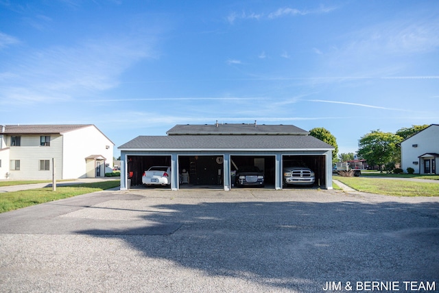 garage with a carport and a lawn