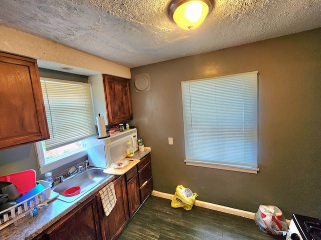 kitchen with sink, dark wood-type flooring, and a textured ceiling