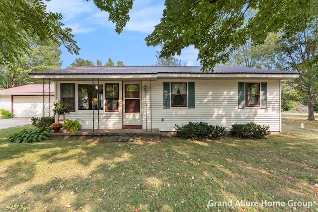 single story home with an outbuilding, a garage, and a front yard