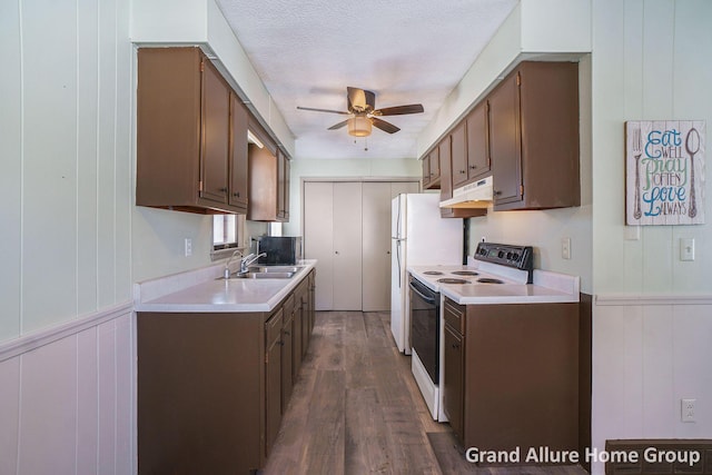 kitchen with sink, white appliances, ceiling fan, dark wood-type flooring, and a textured ceiling